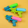 Colorful toy water guns on a yellow background