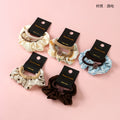 Set of five scrunchies on black cards with 'hand made' text on a pink background
