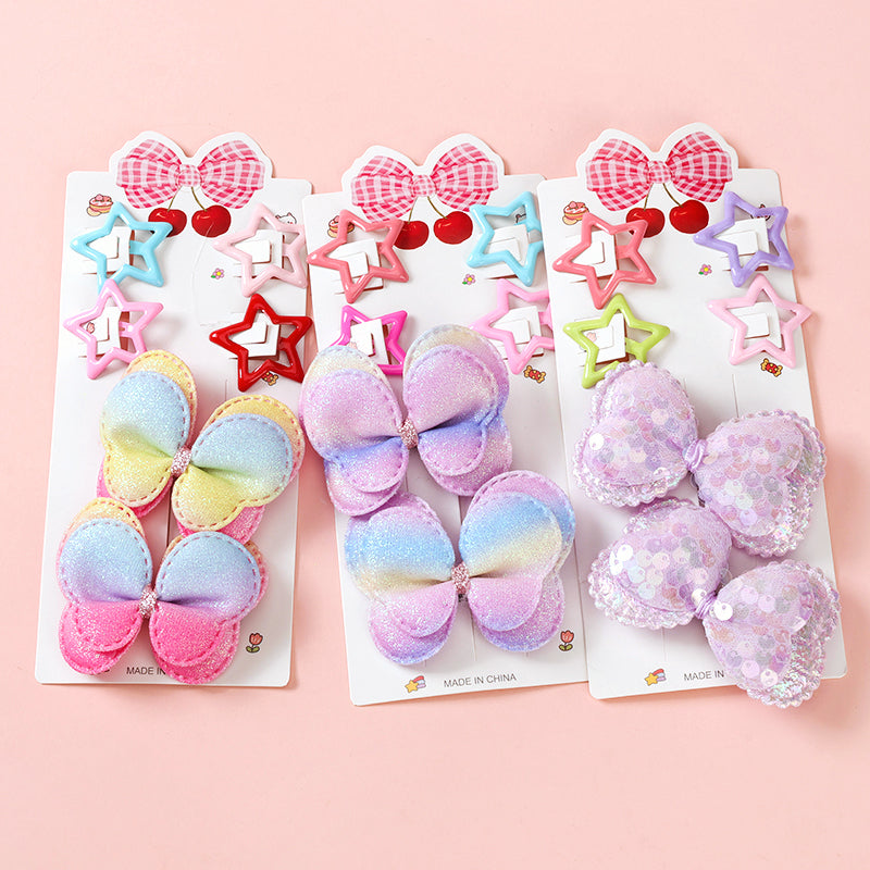 Set of colorful hair accessories including bows and star-shaped clips on a pink background