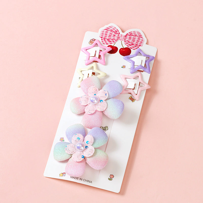 Set of colorful hair clips on a pink background