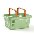 Green shopping basket with brown handles on a white background