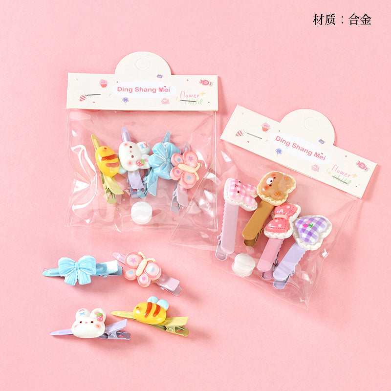 Set of colorful hair clips with packaging on a pink background