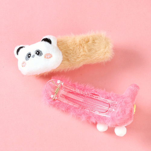 Plush toy resembling a cat with a transparent pink hair clip on a pink background