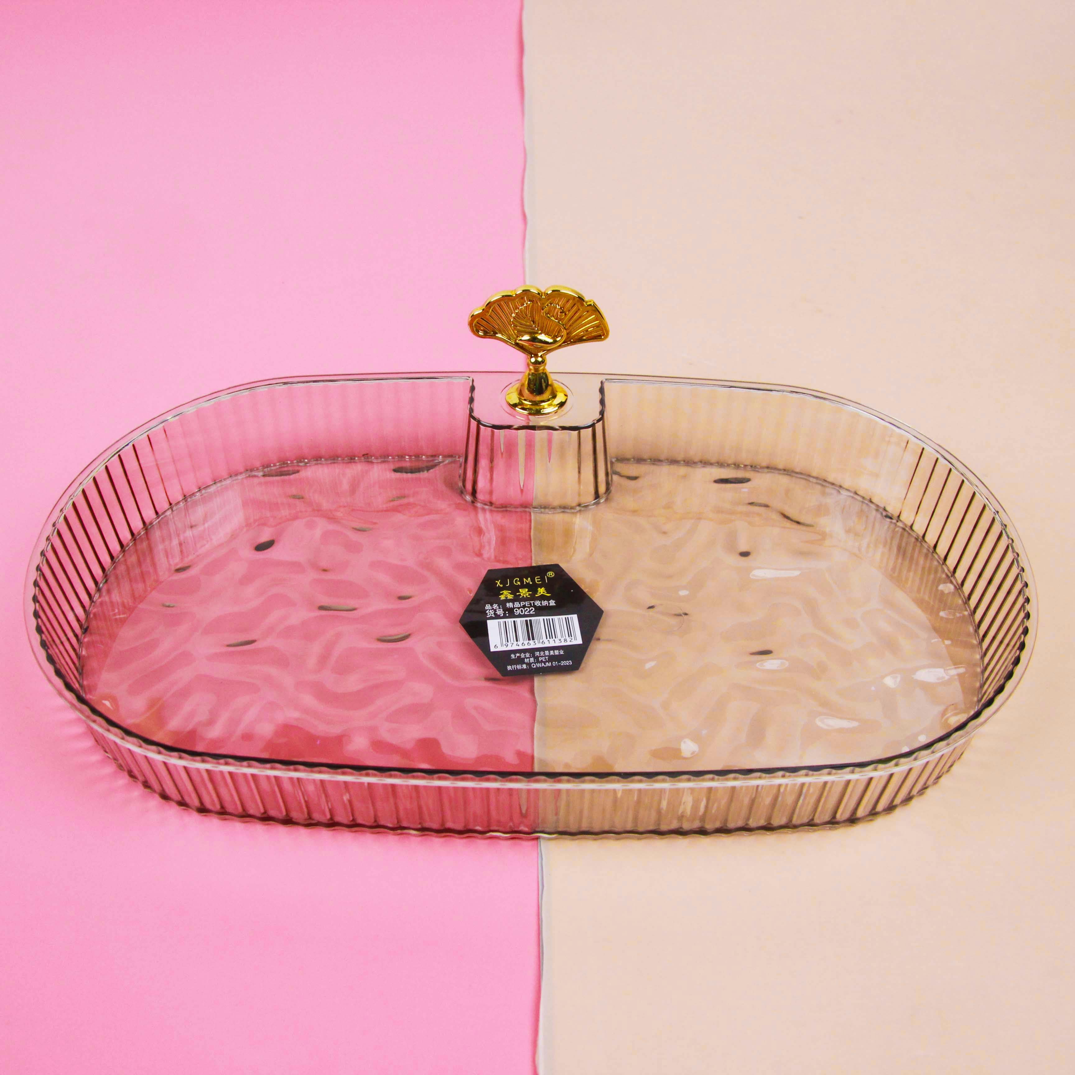 Clear glass tray with gold rim on a pink and beige background