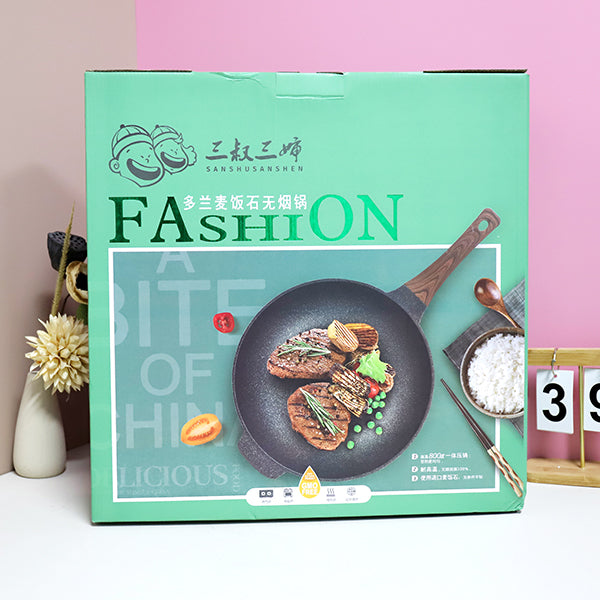 Product packaging with a frying pan illustration and text on a light pink background