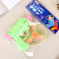 Toy gun with propeller and packaging on a light surface